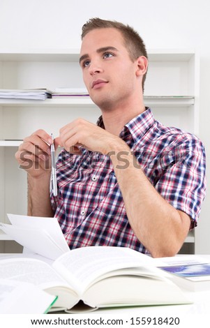 Man sitting in office stretching Man sitting in office and studying