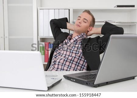 Man sitting in office stretching