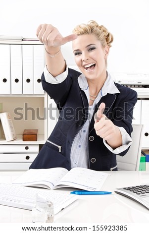 Caucasian blond businesswoman smiling and showing all right with her finger