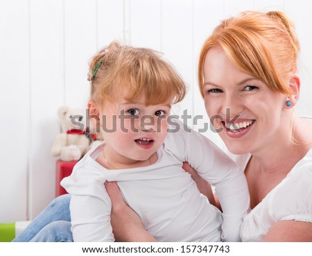Happy family:  mother and daughter smiling at camera - strawberry blonde hair