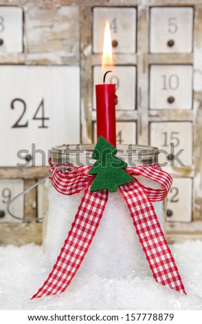 One red advent candle with a red checkered bow for christmas