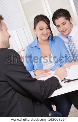 Happy couple discussing future financial plans with consultant at office