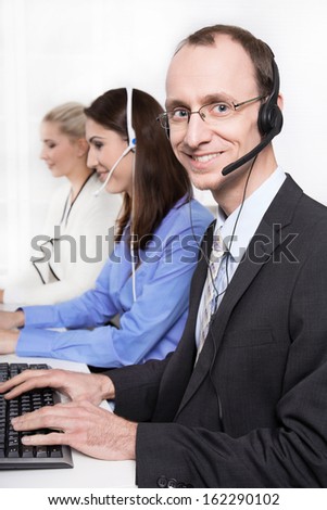 Telesales or helpdesk team - helpful man with headset smiling at camera