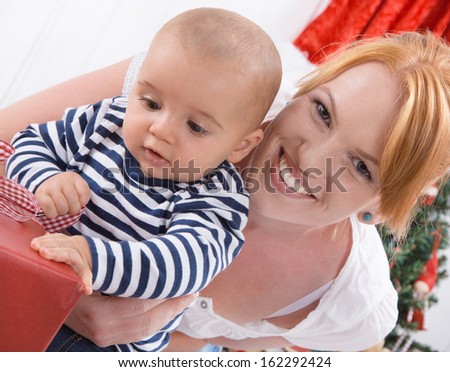 Unconditional love - mother and baby opening a Christmas or birthday present