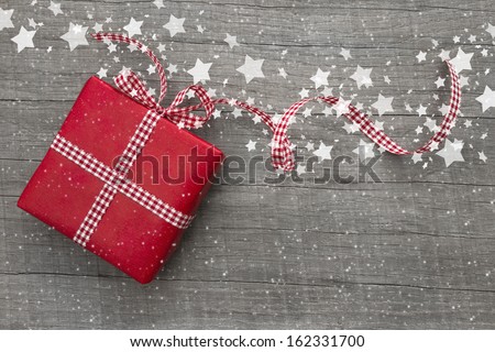 Christmas Present Wrapped In Red Paper On A Wooden Background For A Voucher Coupon - Greeting Card Country Style
