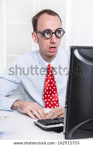 Shocked businessman at desk staring at computer and can\'t believe it - problems at work.