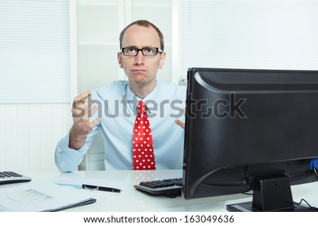 Nervous and aggressive businessman sitting at desk in rage with his computer - data crash.