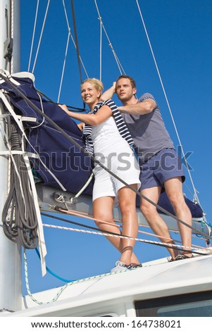 Dreamy attractive couple standing on a sailing boat - in love.