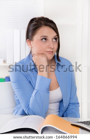 Disappointed, sad and overworked young woman at desk.