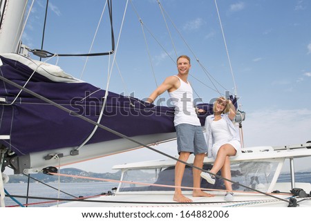 Attractive couple standing on a sailing boat - love.