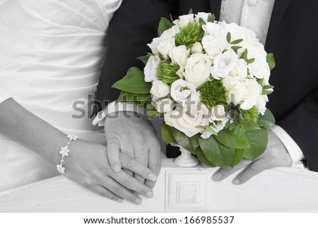 Wedding: Bride and groom holding Hands with bridal Bouquet.