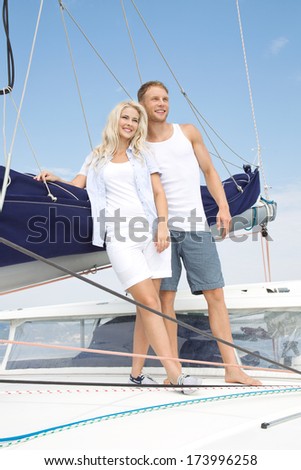 Attractive couple standing on sailing boat - sailing trip.