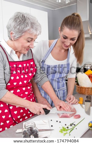 Young woman cooking with her mother in the kitchen.