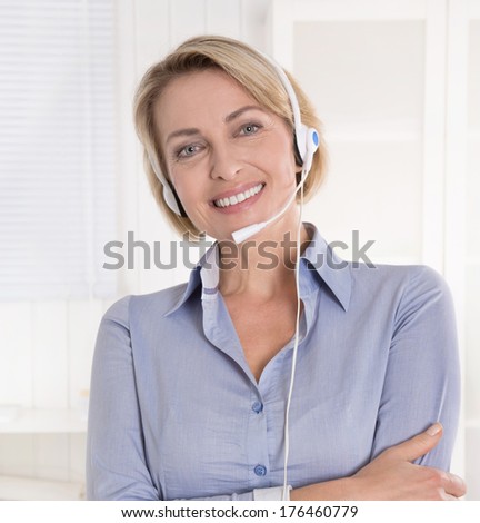 Portrait of blond mature woman in blue blouse with headphone.