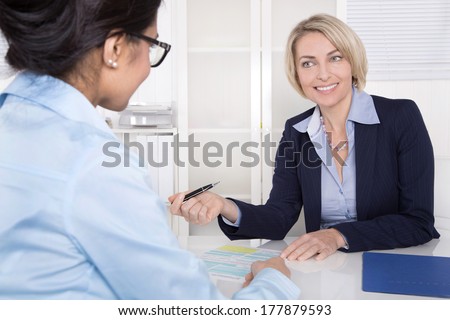 Interview with young female and mature manager at office.