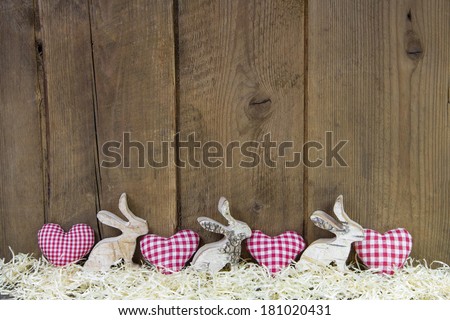 Red checked hearts on wooden background for easter in country style.