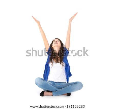 Isolated young woman with hands up sitting in crossed legs on the floor Isolated young woman with hands up sitting in crossed legs on the floor