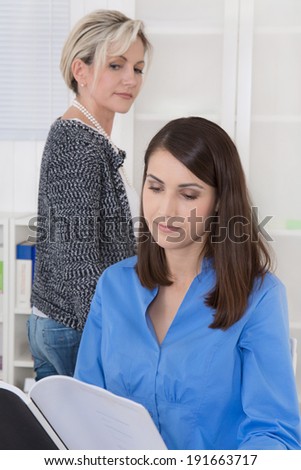 Bullying at work: older business woman is jealous.