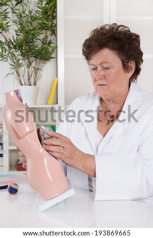 Senior female doctor demonstrate and explain the human body.