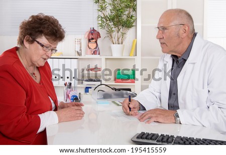 Portrait: older doctor with experience talking with senior woman sitting at desk.