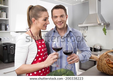 Young fresh married couple in the kitchen cooking together.