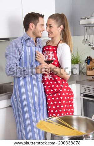Young fresh married couple in the kitchen cooking together.