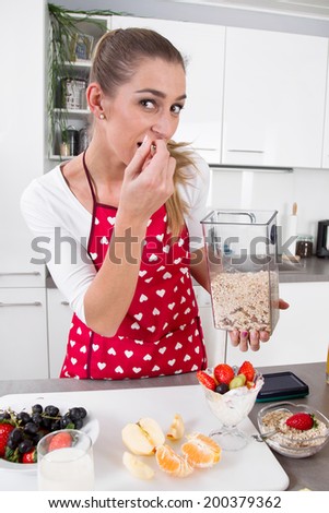 Young woman eating yogurt with fresh fruits in the morning.