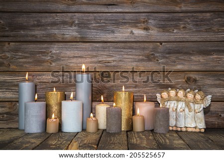 Christmas greeting card with candles and angels on wooden background.