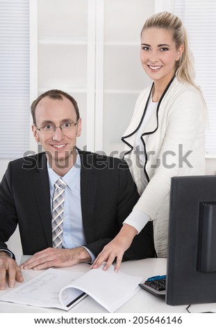 Successful business team: smiling man and woman in portrait in the office.