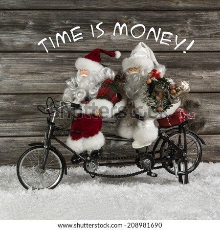 Time is money -  santa claus team in hurry for buying christmas presents. Funny photo in vintage style with an old tandem bike of tin.