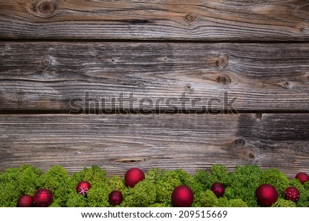 Wooden christmas frame with green moss and red balls for a frame.