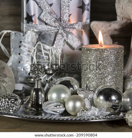 Festive christmas decoration in silver with burning advent candles.