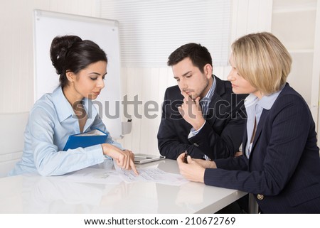 Successful business team sitting at the table in the office.  Male and female people wearing blue clothes.