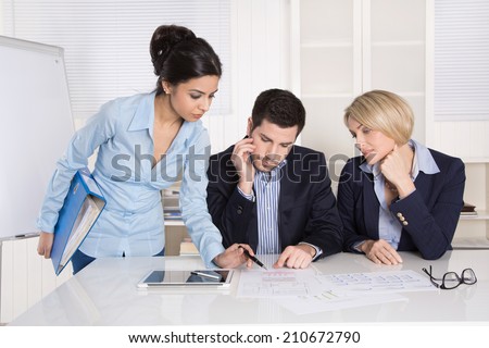 Successful business team sitting at the table in the office.  Male and female people wearing blue clothes.