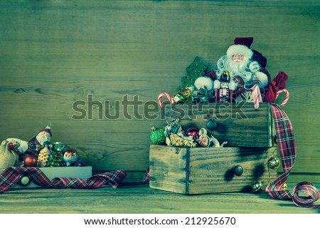 Old christmas decoration with santa on wooden background in green and red.