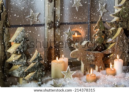 Natural christmas window decoration with handmade reindeer and trees of wood.