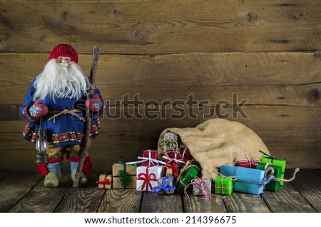 Santa claus on wooden background with colorful presents. Idea for a voucher or gift token.