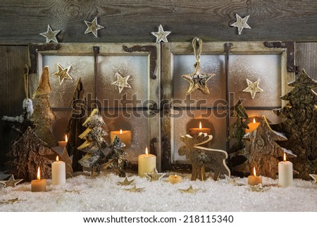 Natural handmade christmas decoration of wood outdoor in the window with candles. Idea for a greeting card.