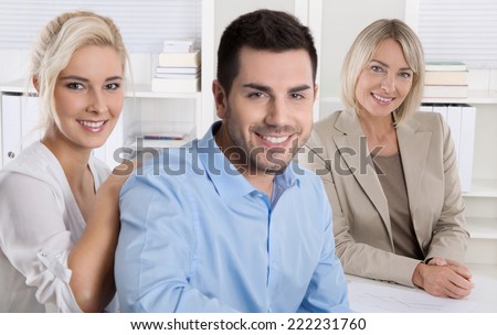 Young smiling couple sitting in a sales conversation at bank or insurance.