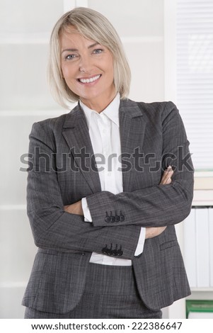 Attractive smiling middle aged businesswoman in portrait wearing business outfit.