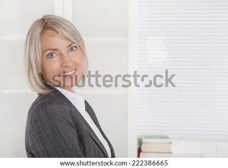 Attractive smiling middle aged businesswoman in portrait wearing business outfit.