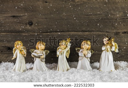 Christmas decoration with angels on wooden snowy background for a greeting card.