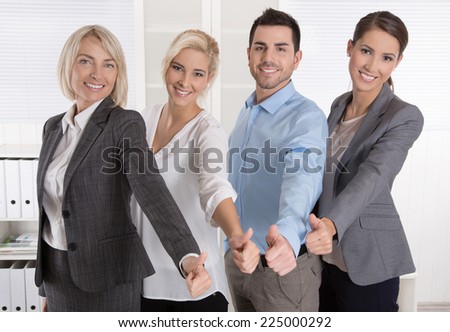 Successful business team in portrait: more woman as men with thumbs up.