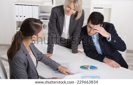 Business team of man and woman sitting around a table talking together in a meeting.