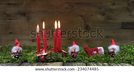 Four red burning advent candles. Christmas background with small handmade gnome.