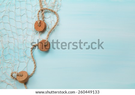 Maritime nautical blue and turquoise wooden background with a fishing net.