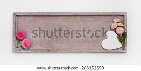 Wooden sign for a background or greeting card with a heart and daisy flowers for easter or spring.