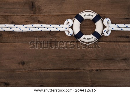 Cooperation concept: Wooden brown nautical background with a blue and white lifesaver.