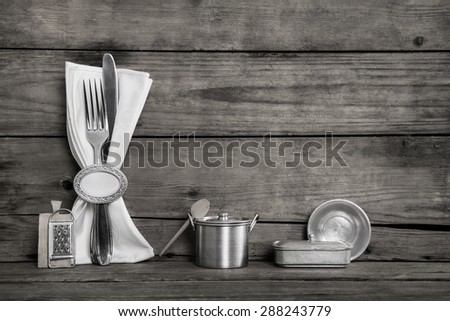 Shabby Chic Style: Old wooden background in grey, white and silver with cutlery and napkin.