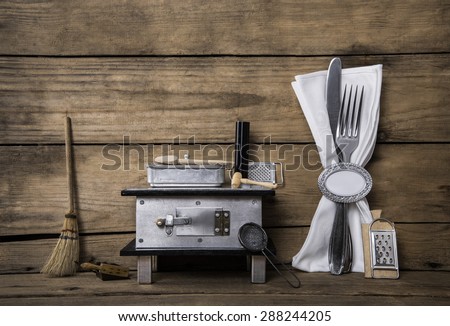 Old miniature of an oven with cutlery on an ancient rustic background for a menu card.